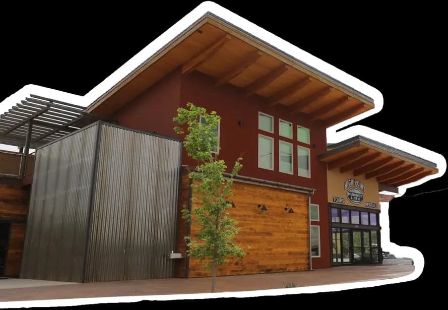 The High Point Hummer & ATV building, with timber siding, a tall overhanging roof and the Tours and Rentals sign above its glass entrance